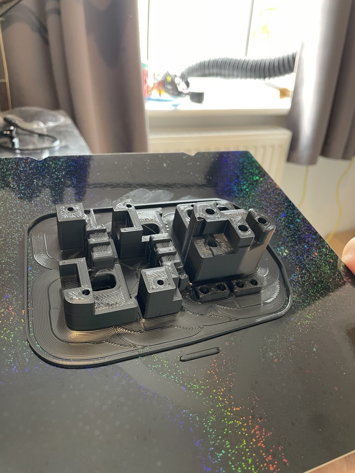 black 3D printed Voron carriage parts with a brim